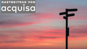 Wegweiserschild im Sonnenuntergang mit Acquisa Gastbeitrag-Logo oben links