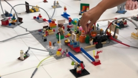Hand baut an einer großen bunten Legoplattform