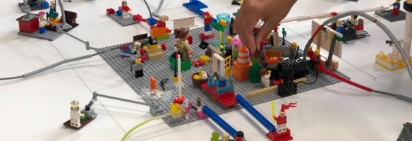 Hand baut an einer großen bunten Legoplattform