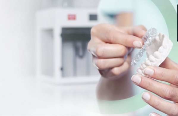 Nahaufnahme von Händen, die ein Zahnarzt-Modell und eine Dentalschiene halten, mit dem Ibexa Award-Badge „Best Customer Project of the Year 2024" oben rechts