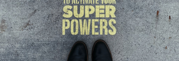 Vogelperspektive auf Asphalt Schuhspitzen mit Stencilspruch: Stand here to activate your superpower