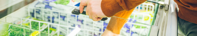 Man öffnet Gefrierschrank im Supermarkt