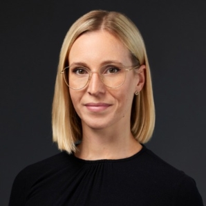 Frau mit Brille und blonden Haaren in schwarzen T-Shirt.