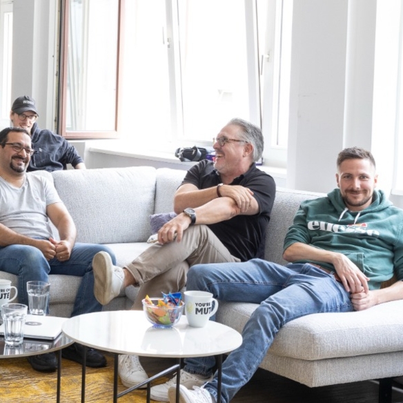 Logic Joe Team laechelnd auf der Office Couch