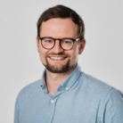 Porträt von Man in blauen Hemd, mit braune Haare und Brille