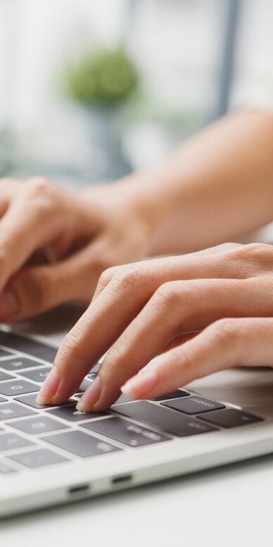Eine Person tippt konzentriert auf einem Laptop-Computer.